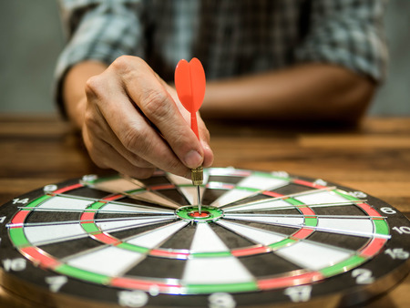 Man holding a dart into the center, business concept, goal conceptの写真素材