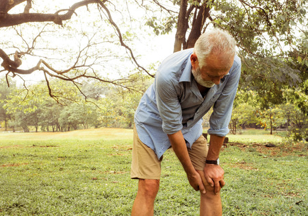 Aging man having pain in his knee on the park, Pain In The Elderly, Health careの写真素材