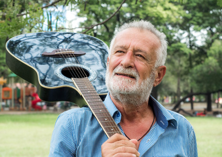 old man standing with guitar