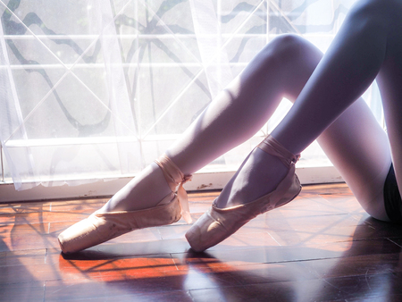 Beautiful legs of young ballerina. Ballet practice. Beautiful slim graceful feet of ballet dancer.