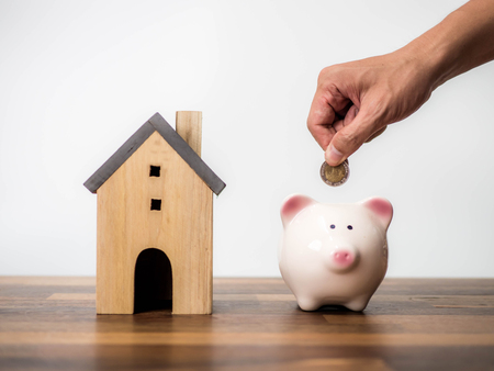 Household savings and finances, Hand putting coin in piggy bank. Saving money conceptの写真素材