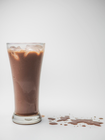 Iced chocolate or cacao in clear glass on white isolated background in side view with copy space. Concept to present bitter sweet and delicious drink.の写真素材