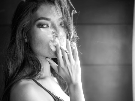 Close up portrait of beautiful woman with smoking, Cigarette smoking is dangerous to health.の写真素材