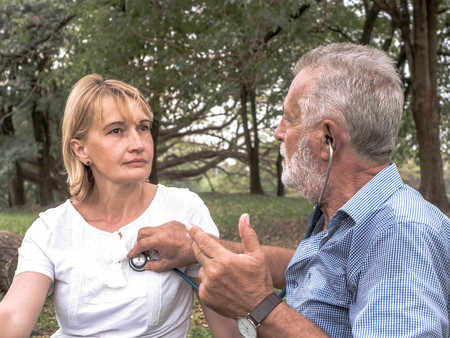Senior man listen to the woman heart with hearing aids and health checks for the elderly, Health...
