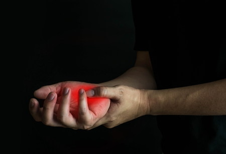 Man with hand injury on black background. Health care and medical conept.の写真素材