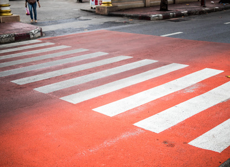 Redâ Crosswalk on the road, Pedestrian crossing with red and white stripes without people close up. The concept of safety on the road.の写真素材