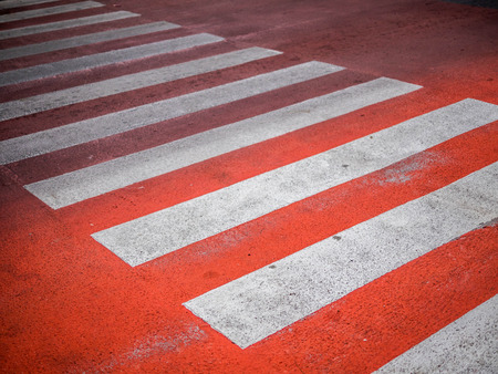 Redâ Crosswalk on the road, Pedestrian crossing with red and white stripes without people close up. The concept of safety on the road.の写真素材