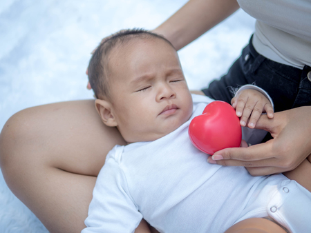 Healthcare and medical love, Newborn baby with red heartの写真素材