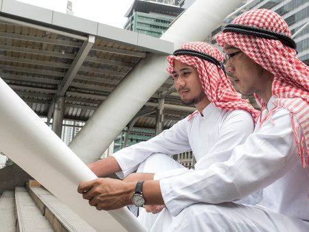 Arab business partners team with blueprint looking away, Arabic business and businessmen working...