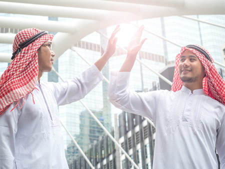 Two Arabic muslim wear white shirt humble say hello in the morning on cityscape background,の写真素材