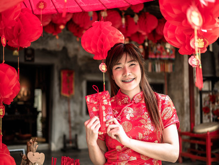 Happy asian girl holding Red Envelope To Give In Chinese New Year Festival. Chinese New Yearの写真素材