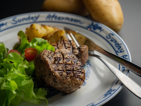 Grilled pork steak with vegetables salad.の写真素材