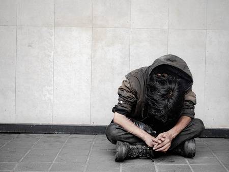 Homeless man on walkway street in the city and begging for help and money. Problems of big modern cities.の写真素材