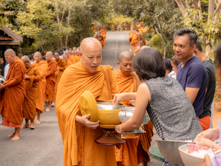 Khao Yai, Thailand - April 23, 2019: Buddhist Monks Line up in Row Waiting for Buddhism People to Give Alms Bowl in Makut Khiriwan Temple.のeditorial素材