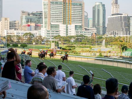 Bangkok, Thailand - Feb 24, 2019: Group of horses charging for the finish line during racing day at...