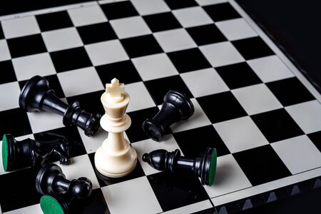 Chess king standing wins the game of chess setup on dark background. Chess concept save the king and save the strategy, game over.の写真素材