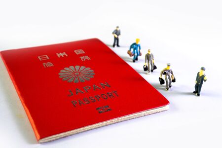 Small figure people and Japanese passport. Travel to the country.の写真素材