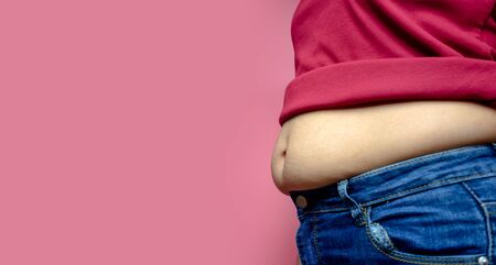 Overweight fat woman isolated on a pink background in Studio, Weight losing, obesity, cellulite, health care concept. copy space background for textの写真素材