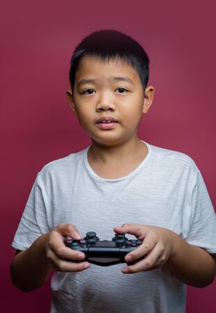 Bangkok, Thailand - September 12, 2019: Hand boy playing Sony Dualshock 4 controller for PlayStation 4 pro, video game-addicted children.のeditorial素材