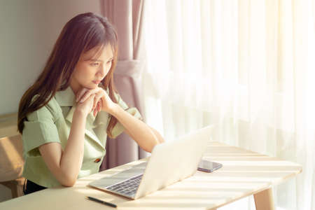 businesswoman thinking reading news e-book on laptop, focused student studying or working on...