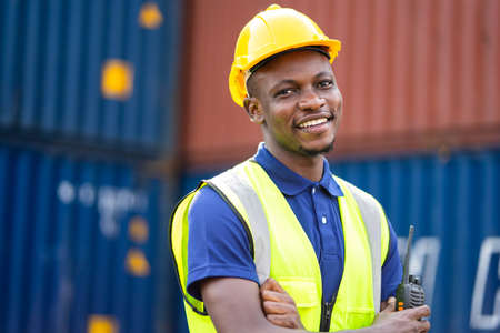 American African engineer or factory worker man at Container cargo harbor to loading containers. African dock male staff for Logistics import export shipping concept.の写真素材