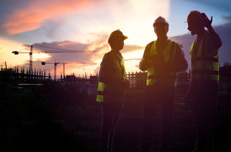Teamwork, worker in uniform and wearing safety helmet while working on commercial dock site with...