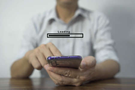 Close up of Businessman hand holding mobile smartphone with cloud upload to store data on server.