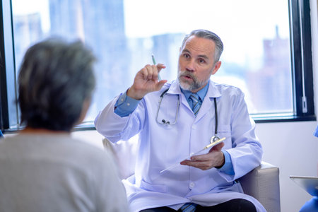 Male doctor consulting senior old patient. Doctor with patient in medical office.の写真素材