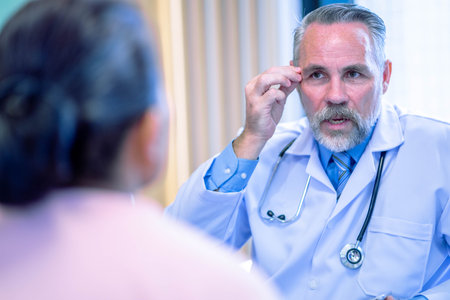 Male doctor consulting senior old patient. doctor talking to a patient in the officeの写真素材