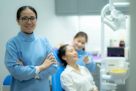 portrait of a Asian Woman dentist with her team working in the backgroundの写真素材
