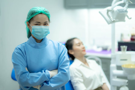 Asian woman dentist doctor and female patient in chair smiling at camera, Visiting dentist.の写真素材