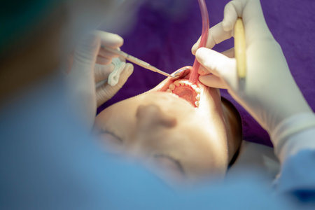 Dentist with an assistant in protective gloves are examining her teeth with a help of a dental bur with a mirror and an air polisher. Caries healing. Examination of the dentist.の写真素材