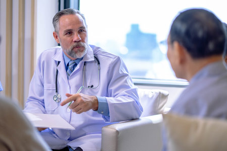 Doctor consulting senior old patient. doctor talking to a patient group in the officeの写真素材