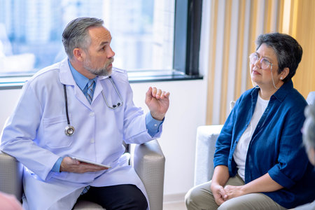 Doctor consulting senior old patient. doctor talking to a patient group in the officeの写真素材