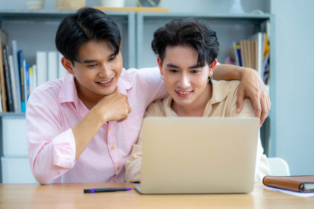 Homosexual couple enjoying using digital tablet at homeの写真素材