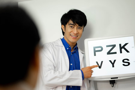 man optician doing snellen eye test to patient at clinicの写真素材