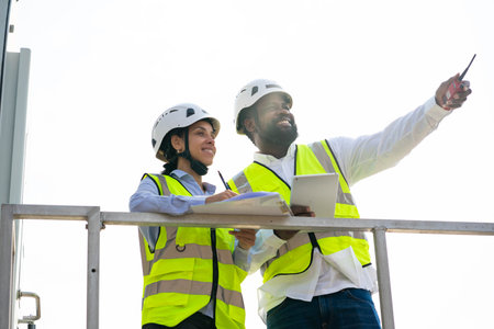 Two industrial engineer working near the electrical plant for discussed the plan for the...