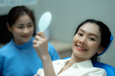 Woman looking at her teeth. Smiling lady at dentist office.の写真素材