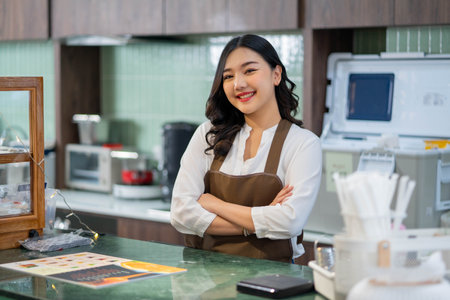 Smiling waiter stands behind the counter while waiting for a customer, retail small business owners.の写真素材