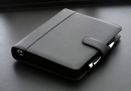 A diary on a desk with a penの写真素材