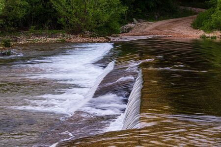 The water of Spring Creek flowing over the concrete slab bridge located in Teresita, Oklahoma 2019の写真素材