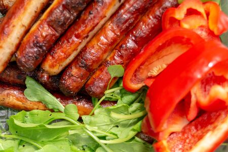 sausages are fried in the grill and arugula, red bell pepper.の写真素材