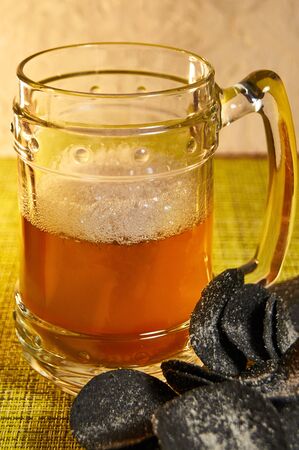 Black chips and beer. Alcoholic drink and snacks. Original beer snack. The chips with the addition...