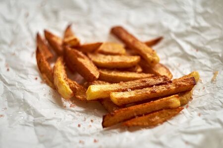 Tasty homemade potato french fries on white paper background.の写真素材