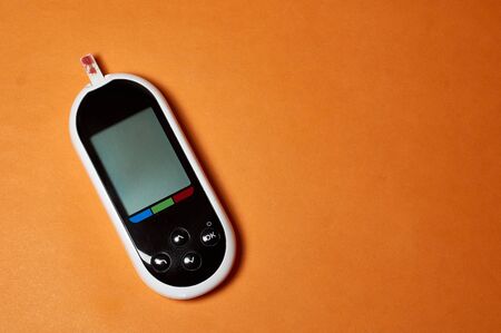 A diabetic checks his blood sugar. Close up man hands self-tested with a Lancet and a glucometer at...