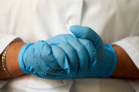 hands of a girl in a lab coat and medical gloves.