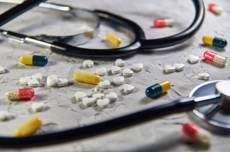 a stethoscope and heart-shaped pills. Concept of treatment of heart diseasesの写真素材