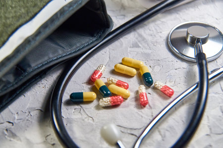 a stethoscope and heart-shaped pills. Concept of treatment of heart diseasesの写真素材