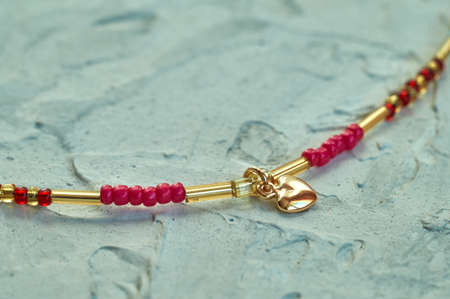 Handmade beadwork, beading as a hobby. Decorations made with your own hands on the background of various flowers and plants.の写真素材