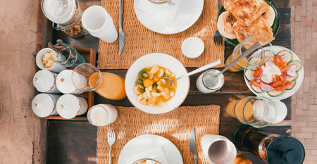 Authentic Moroccan breakfast spread with fresh fruits, flatbread, and juice in a traditional luxury riad hotel outdoor courtyard, top-down overhead shot view Marrakech, Moroccoの写真素材